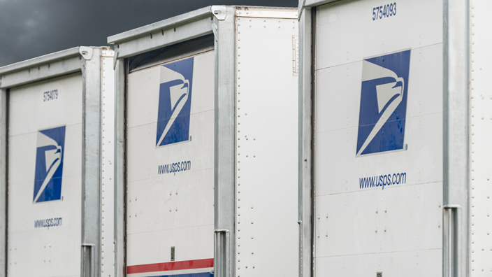 A row of USPS-branded trucks