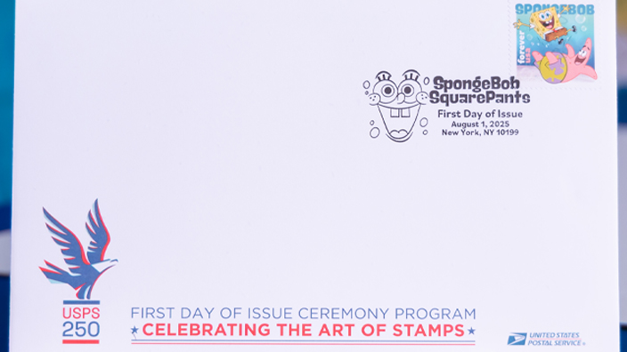 An envelope with a SpongeBob SquarePants stamp is displayed on a table