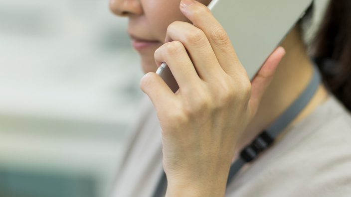 A woman holds a mobile phone to her ear