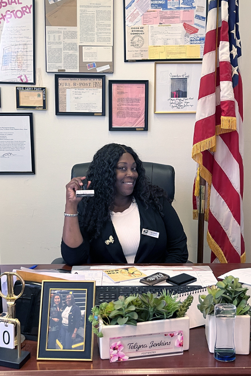 A woman smiles and holds a handstamp