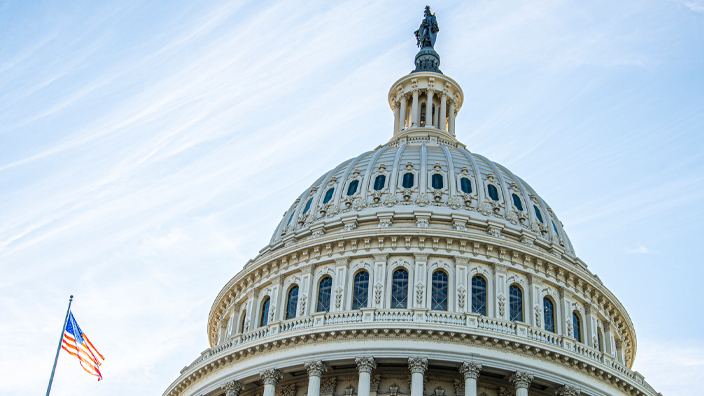 The dome of the U.S. Capitol with the U.S. flag flying nearby