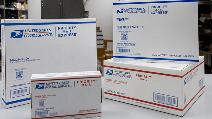 An array of USPS-branded shipping products on a table in a Post Office workroom