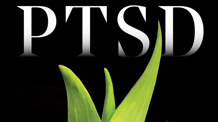 A stamp with a green plant breaking through a bed of dead, brown leaves.