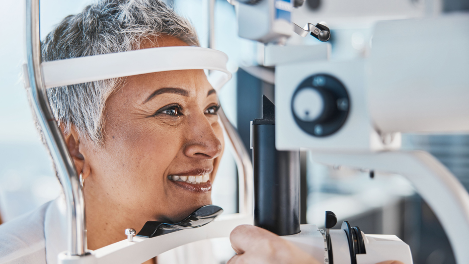 A woman sits in an eye doctor’s office as her eyes are examined