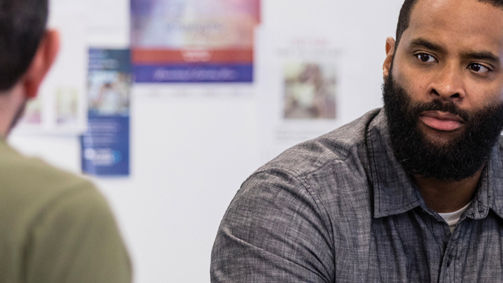 A veteran sits with his hands clasped.