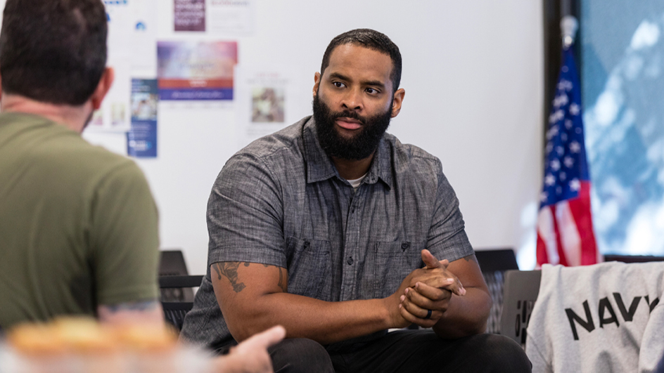 A veteran sits with his hands clasped.