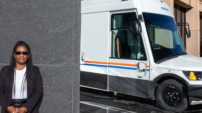 A woman stands in front of the USPS headquarters building in Washington, DC