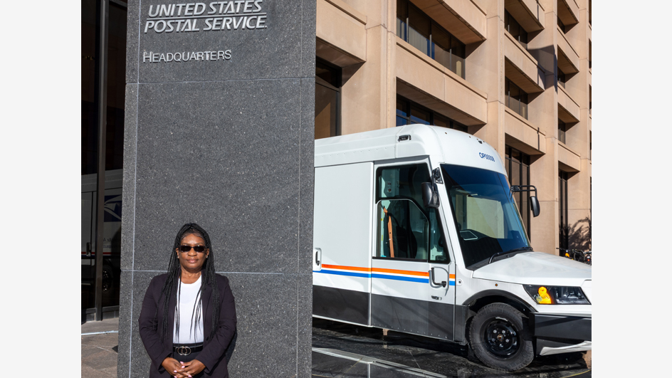 A woman stands in front of the USPS headquarters building in Washington, DC
