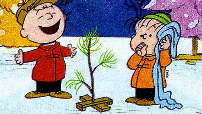 A stamp depicting Charlie Brown and Linus among Christmas trees