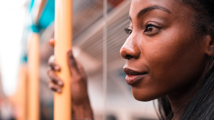 A woman stands on a commuter train