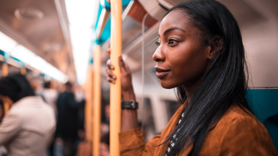 A woman stands on a commuter train