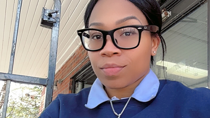 A female employee wearing a blue United States Postal Service sweatshirt