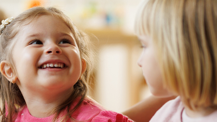 A preschool teacher tends to young children