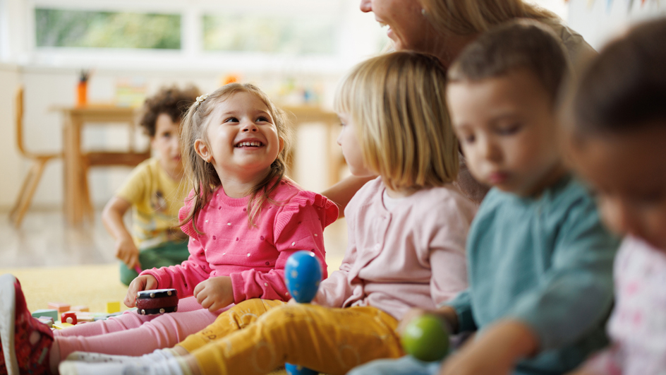 A preschool teacher tends to young children