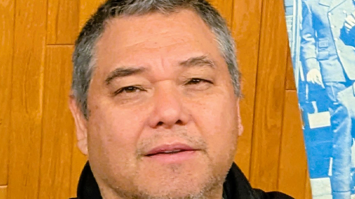 A smiling man holds aloft a 1940s-era publication