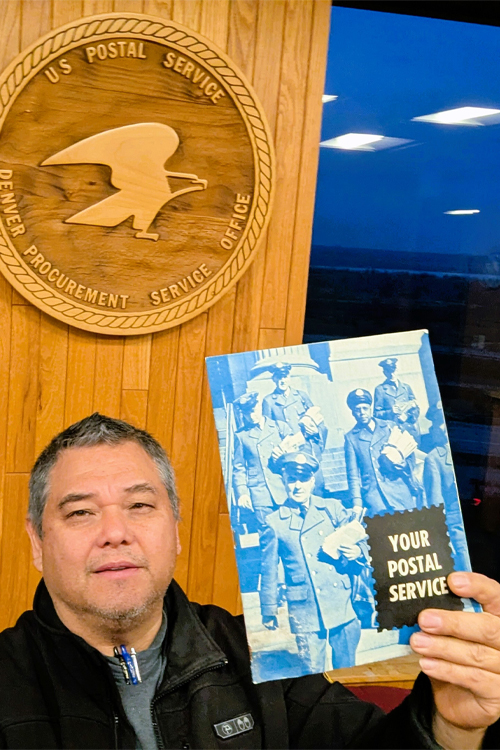 A smiling man holds aloft a 1940s-era publication
