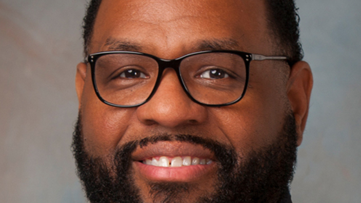 Studio portrait of a smiling man in a business suit