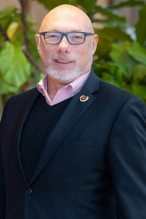 A man wearing a sport jacket smiles