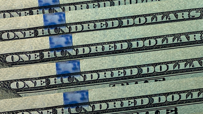 One-hundred-dollar bills laying on top of each other