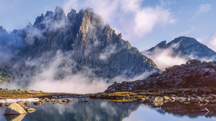 The Colorado Statehood stamp showing a photograph of a jagged mountain reflected in a natural pool of water.