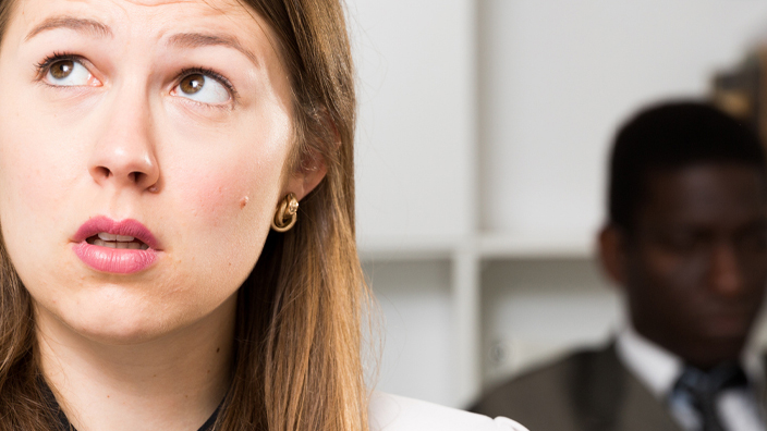 A woman with a ponderous expression in an office setting