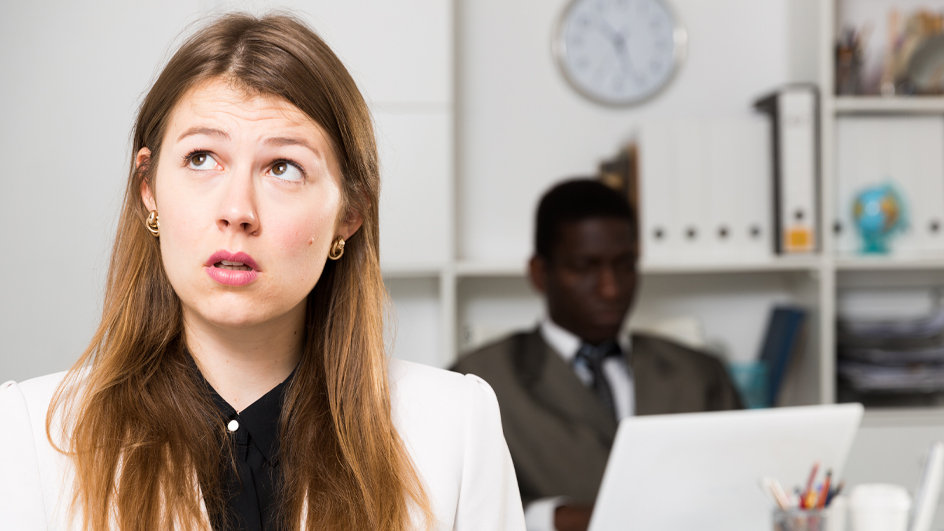A woman with a ponderous expression in an office setting