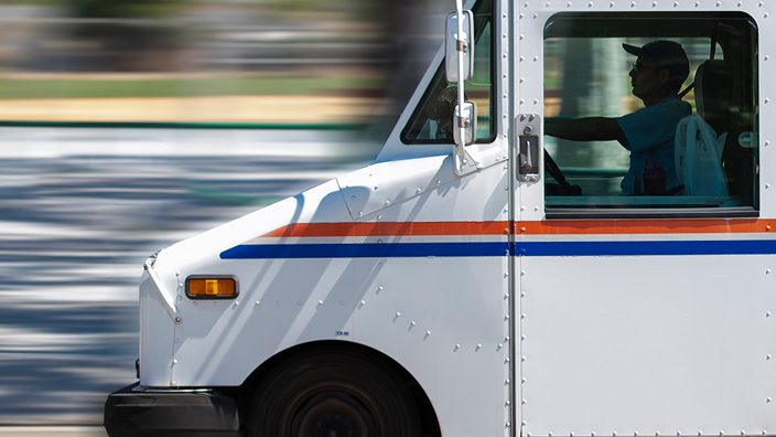 Profile of an LLV delivery vehicle driving down the road