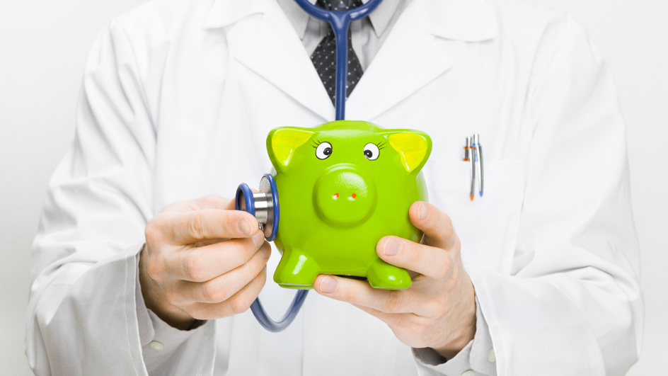 A doctor in a white lab coat uses a stethoscope to listen to a green piggy bank.