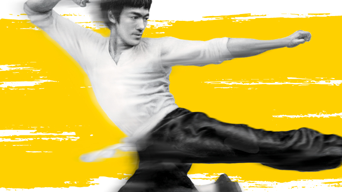 A postage stamp showing a man with a white shirt and black pants performing a kick while in mid-air.