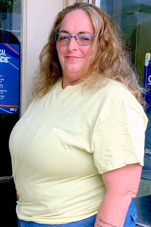 A woman stands near a bank of Post Office boxes