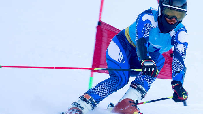A downhill ski racer on a snowy mountain