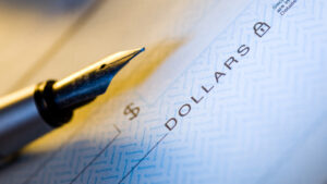 Partial image of a fountain pen sitting on top of a blank check