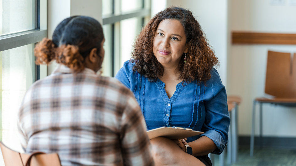 Two women in casual clothing having a discussion.