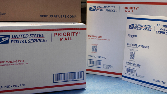 USPS Priority Mail and USPS Ground Advantage shipping boxes and envelope on a counter