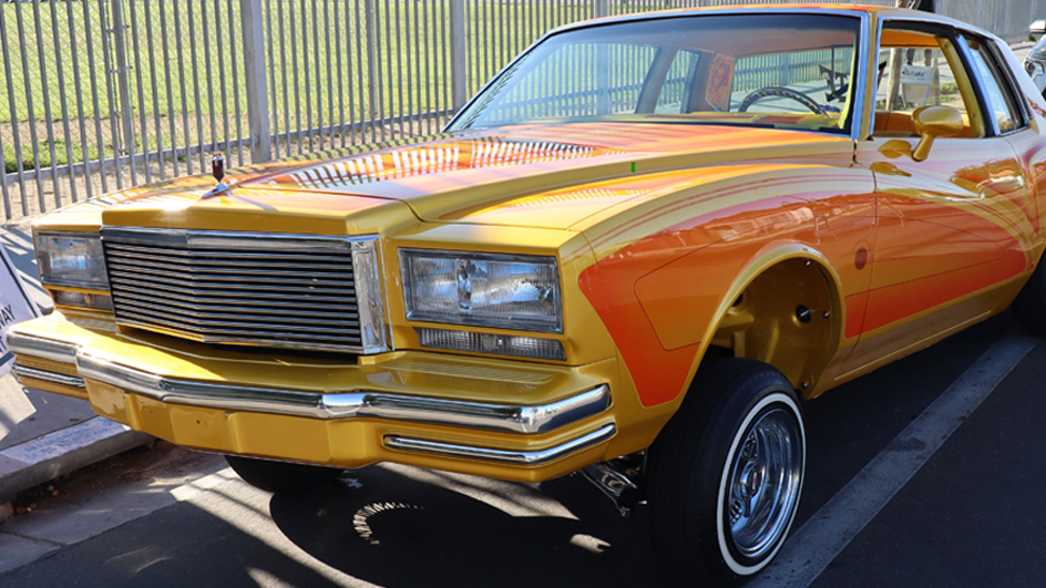 An orange-and-yellow Oldsmobile lowrider car