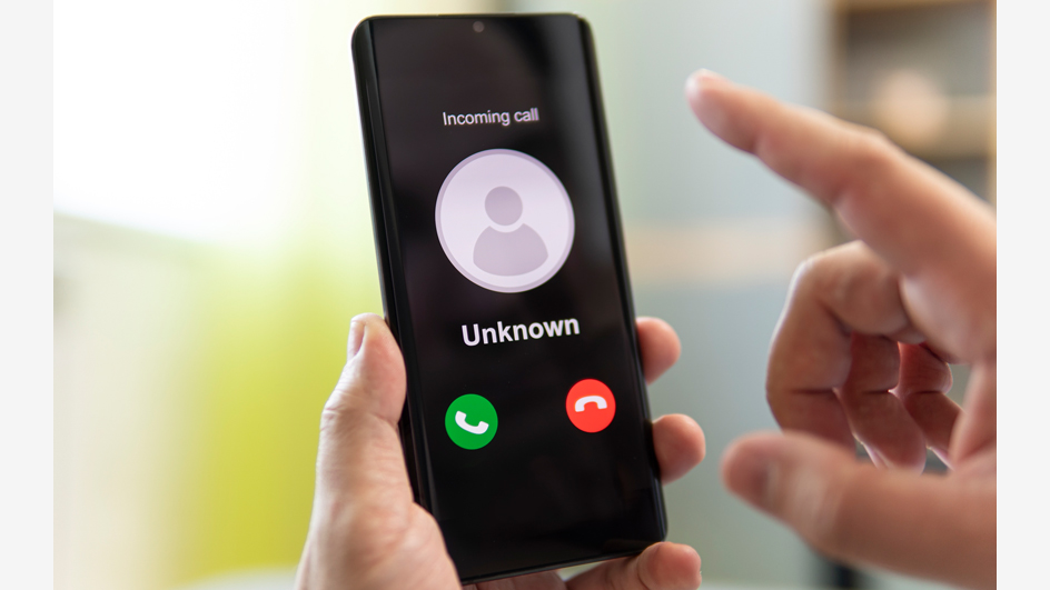 Person holding phone in hand displaying an incoming unknown call