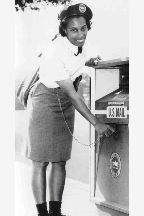 Black-and-white photo of a female postal worker placing mail into a U.S. Mail collection box