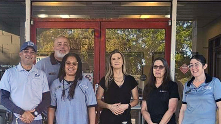 USPS employees standing outside of the Jensen Beach, FL, Post Office