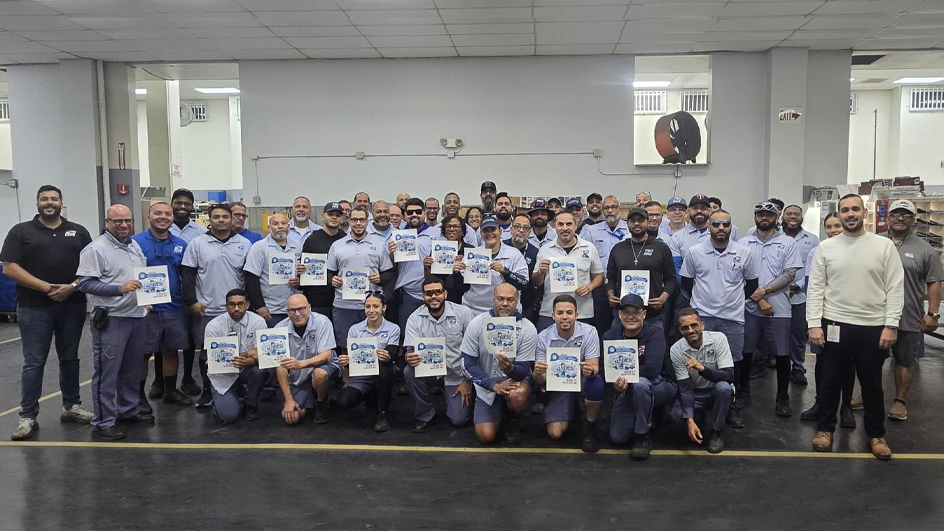A large group of USPS employees, each one posing with a seat belt pledge poster