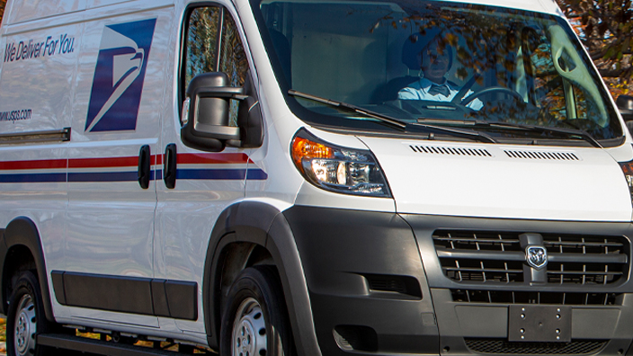 A delivery van on a tree-lined street