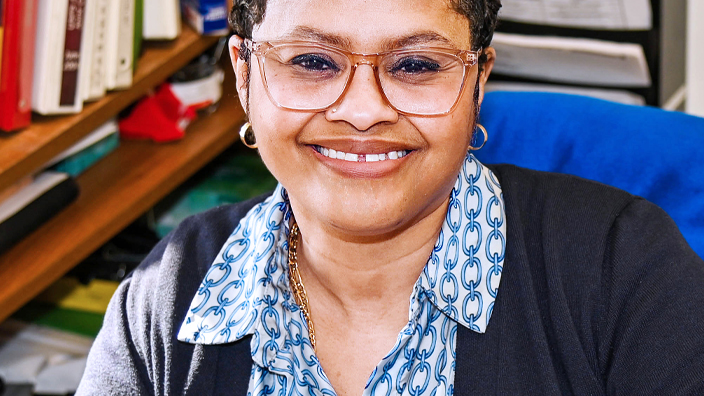 USPS employee sitting at a desk in an office