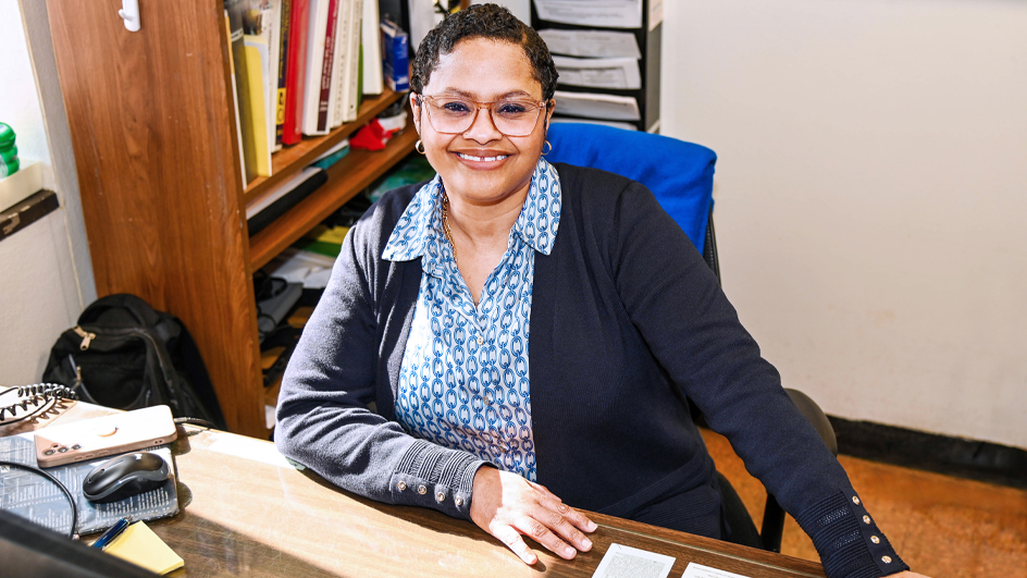 USPS employee sitting at a desk in an office