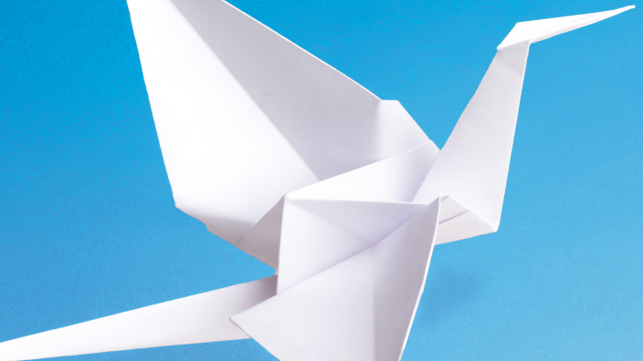 The USPS International Peace stamp shows a white paper crane on a blue background.