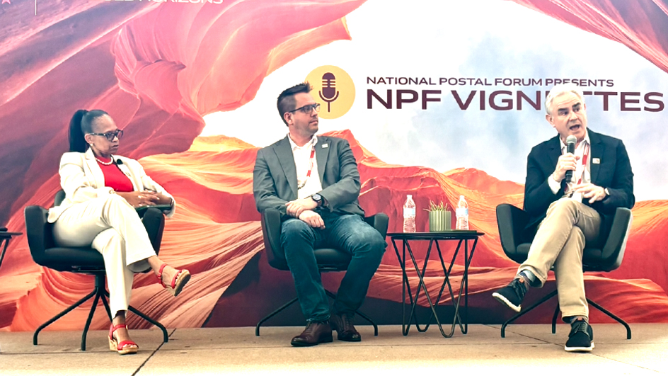 Three people sit side by side on a stage in front a desert-themed backdrop for a panel discussion