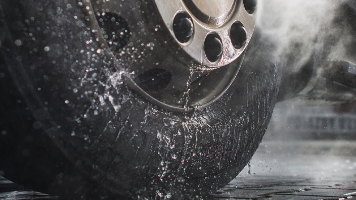 A vehicle tire getting sprayed with water