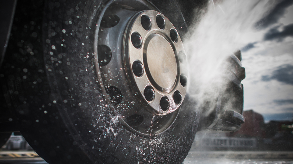 A vehicle tire getting sprayed with water