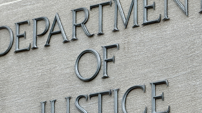 Letters spelling out “Department of Justice” affixed to the side of a building