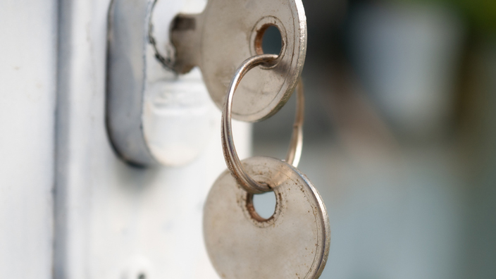 Keys dangling in the lock to a door