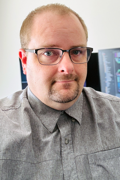 Man wearing glasses and a gray button-up shirt