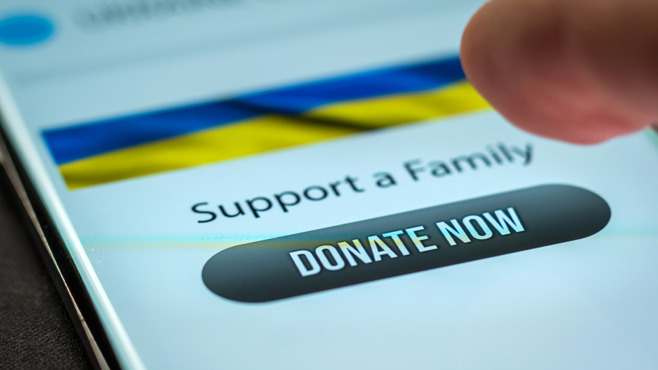 Phone screen showing a ‘Support a Family’ message and a ‘Donate Now’ button